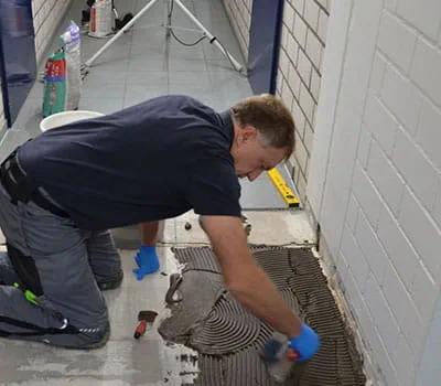 Nanesení a rozetření lepidla na dlaždice