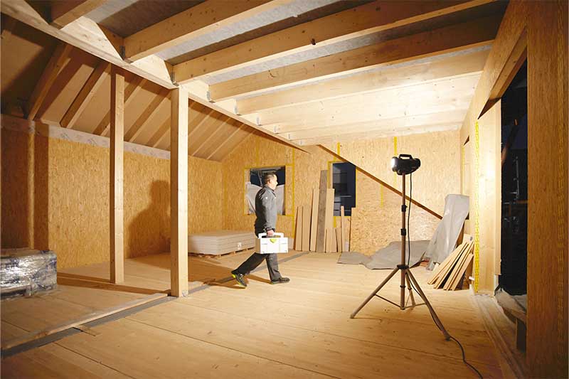 Stavební světlo osvětluje tmavou místnost bez oken.